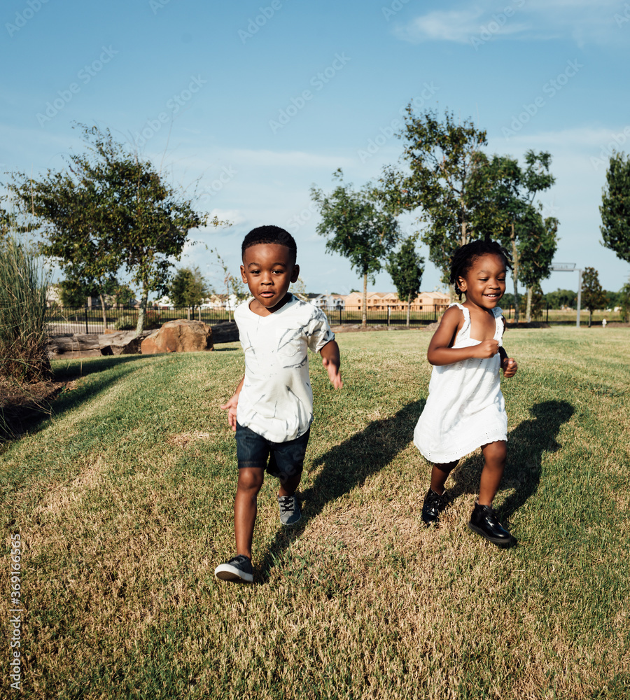 Brother and sister racing at park Stock Photo | Adobe Stock