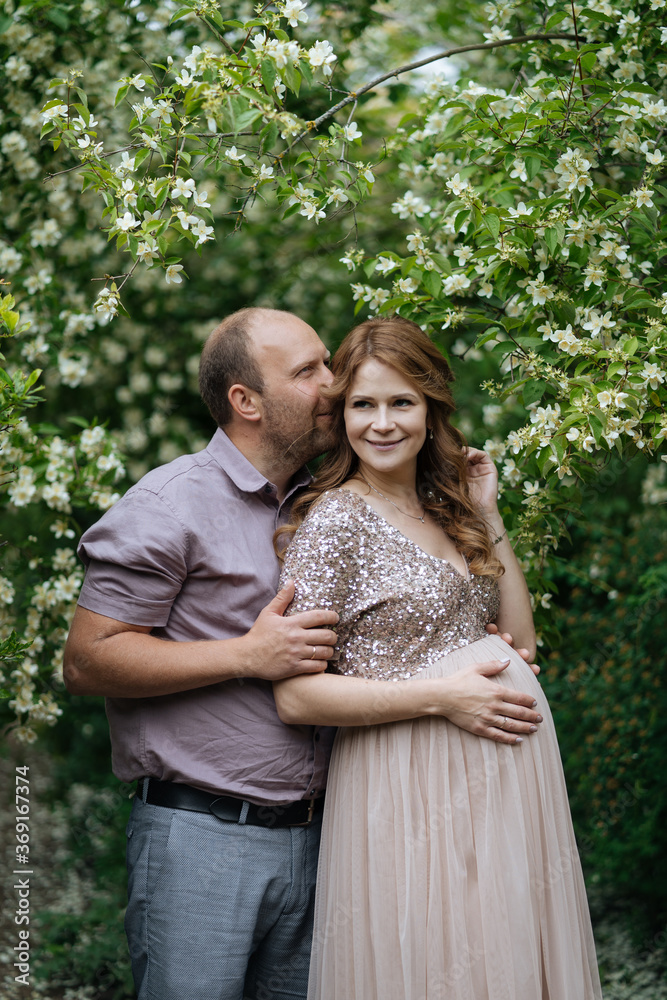 Happy couple standing near blooming tree Happy couple standing near blooming tree