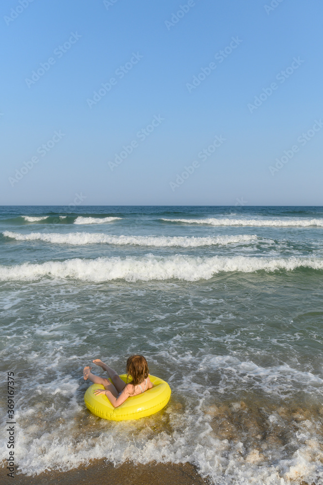 Girl riding waves in inner-tube Girl riding waves in inner-tube