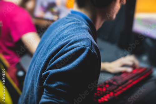 Cyber sport e-sports tournament, team of professional gamers, close-up on gamer's hands on a keyboard, pushing button, gamers playing in competitive moba/strategy fps game on a cyber games arena club