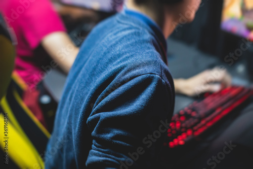 Cyber sport e-sports tournament, team of professional gamers, close-up on gamer's hands on a keyboard, pushing button, gamers playing in competitive moba/strategy fps game on a cyber games arena club
