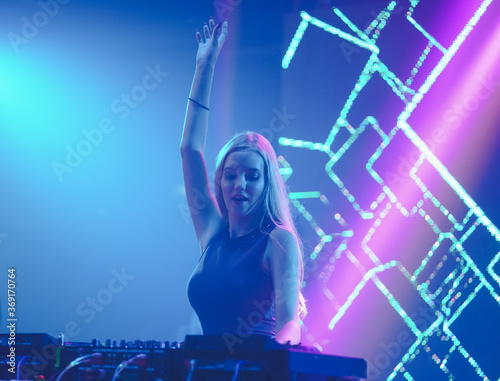 girl dj playing music at the clup, even concert night dj party. photo