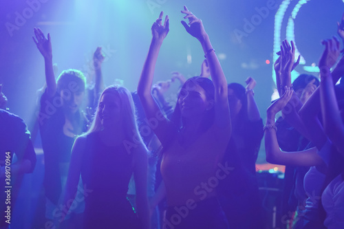 group of young girl dancing in the nightclub, young lady with shape heart in event concert