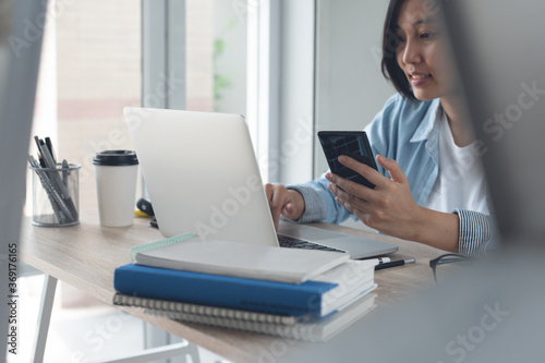 Asian business woman online working on laptop computer from home office