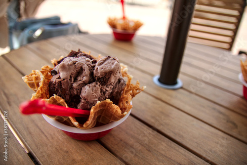 chocolate ice cream in a waffel bowl looks very delicious and creamy. you can get ice cream at the mall and it's a great way to have a fun time with friends and family. chocolate ice cream is yummy