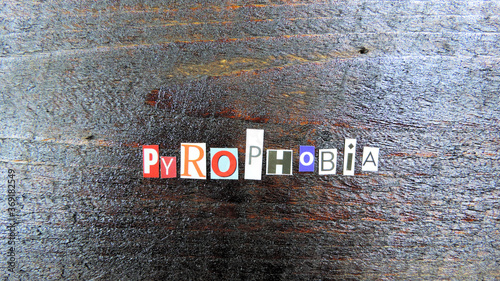 Pyrophobia word from paper letters on wooden boards, fear of fire and sparks photo