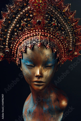 Head of woman mannequin in red decorated head wear, black studio background © EVGENY FREEONE
