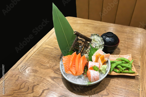 Closeup on traditional japanese food sushi sashimi set with japnese green beans and soup on texture wooden table in restaurant. photo