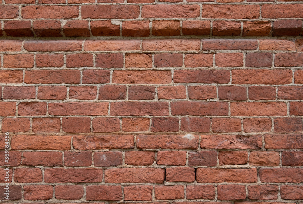 A close-up of a fragment of an old historical brick wall. Horizontal orientation, selective focus. A close-up of a fragment of an old historical brick wall. Horizontal orientation, selective focus.