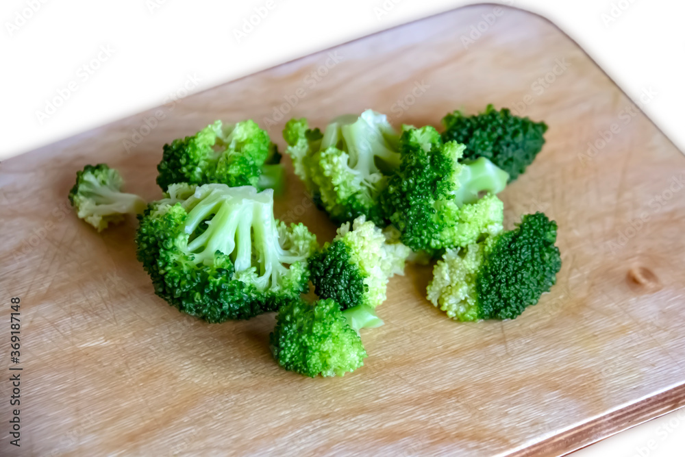 broccoli cabbage on wood board. Fresh green organic broccoli vegetable on a woofen cutting board on a light rustic wooden background. view from above. close-up broccoli cabbage on wood board. Fresh green organic broccoli vegetable on a woofen cutting board on a light rustic wooden background. view from above. close-up