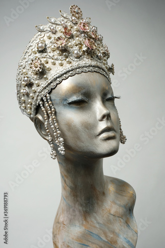 Head of mannequin in creative white headwear with flowers and pearls