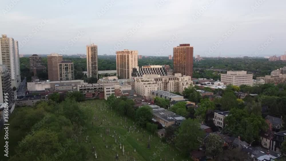 Rising drone shot of cemetery hidden in the middle of downtown Toronto, Canada. The Toronto Ravine (forest) is shown in the background. Rising drone shot of cemetery hidden in the middle of downtown Toronto, Canada. The Toronto Ravine (forest) is shown in the background.