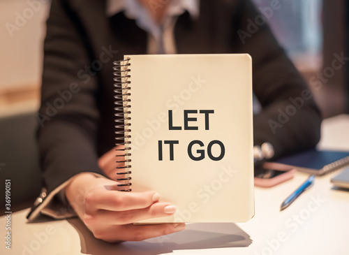 Obraz na plátně business woman holding a notebook with the text LET IT GO