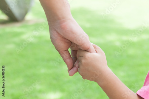 Hand of Parent and Child hold together while travel outdoors © thampapon1