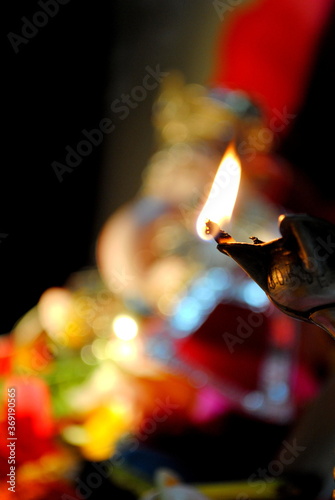 burning lamp in front of lord GANESHA also known as INDIAN Elephant god . photo