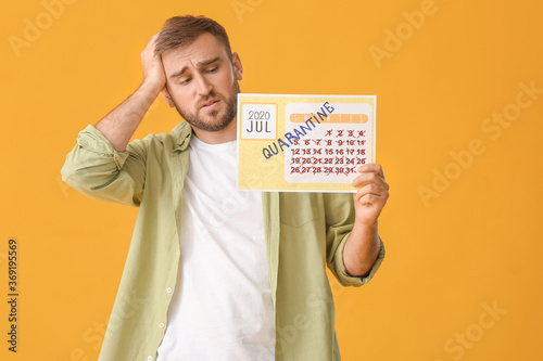 Sad man holding calendar wi...
