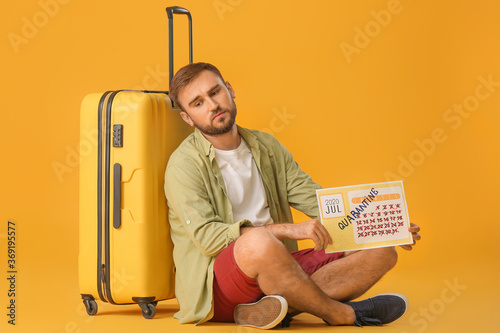 Sad man holding calendar wi...