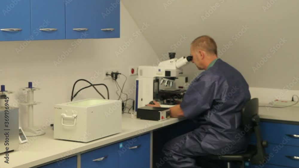 A Laboratory Worker Watching Samples Through a Microscope A Laboratory Worker Watching Samples Through a Microscope