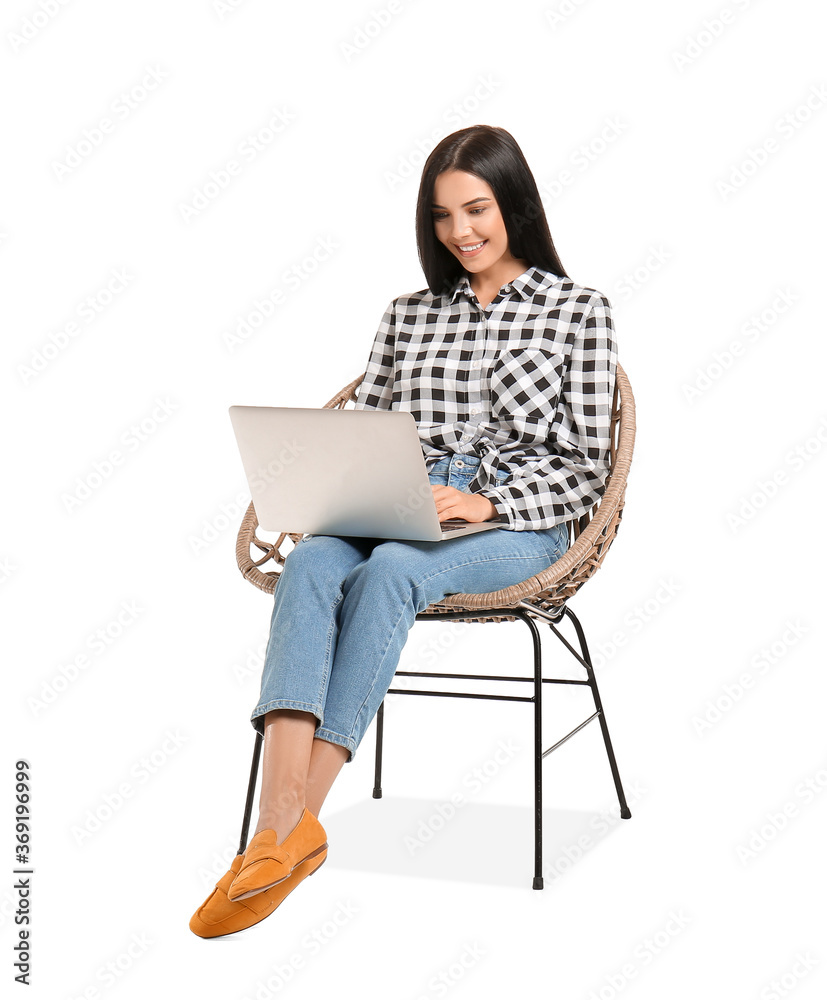 Naklejka premium Young woman with laptop relaxing in armchair on white background