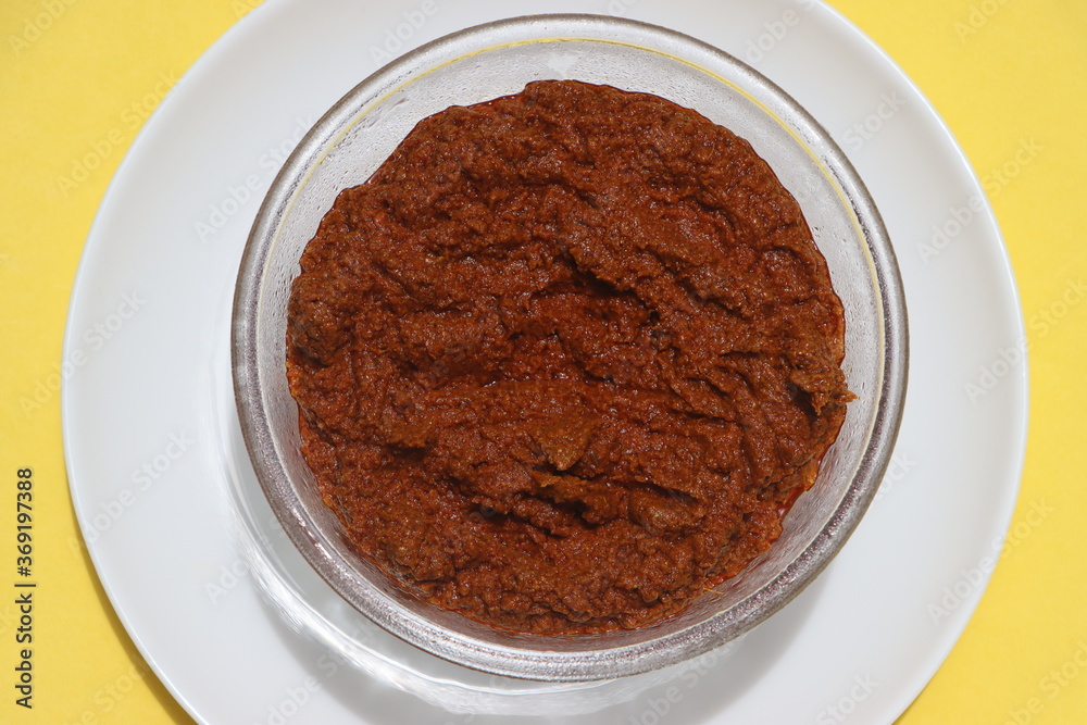 Red curry paste in glass bowl, basic ingredient for Indian curry or gravy made with various spices, tomatoes and onions. Red curry paste in glass bowl, basic ingredient for Indian curry or gravy made with various spices, tomatoes and onions.