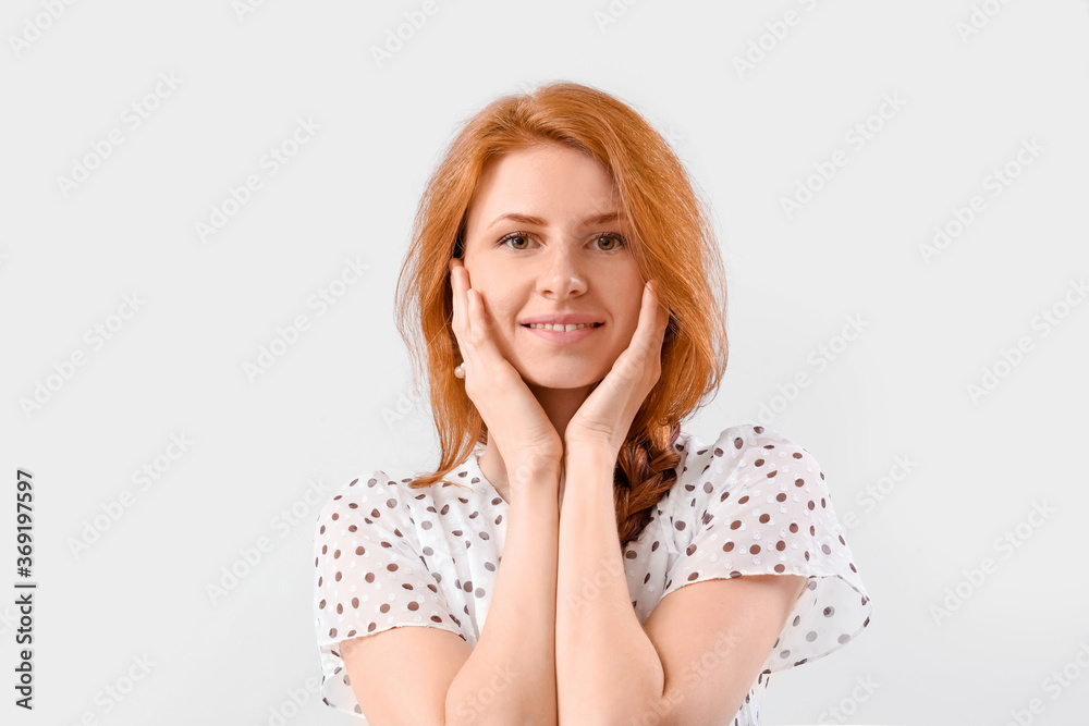 Beautiful young redhead woman on light background Beautiful young redhead woman on light background