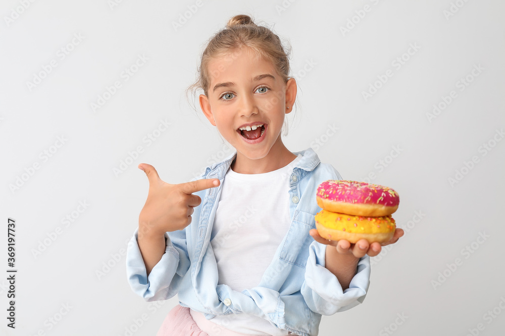 Funny little girl with donuts on light background Funny little girl with donuts on light background