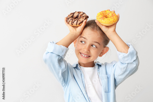 Funny little girl with donu...