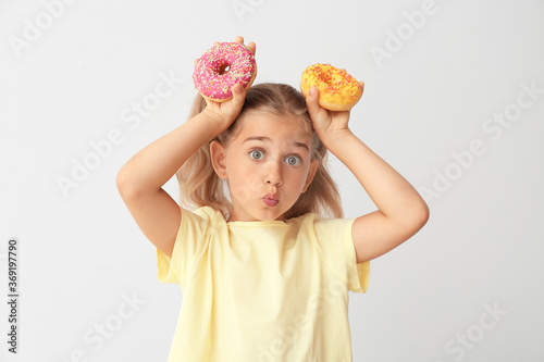 Funny little girl with donu...
