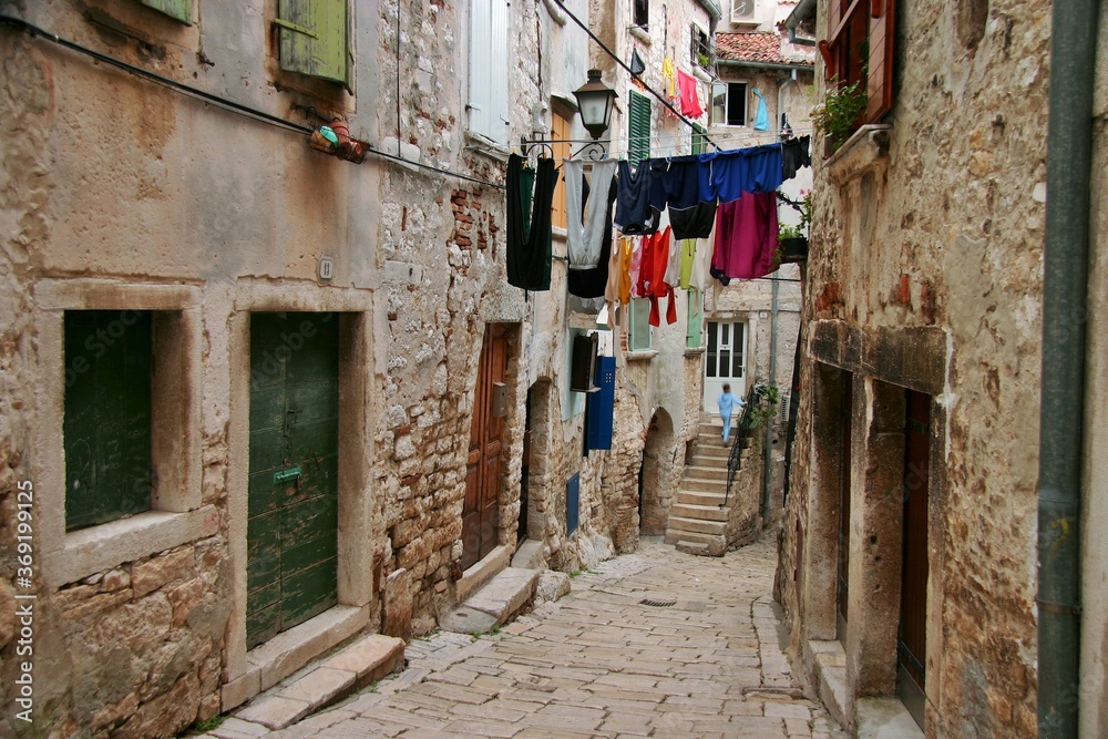 A narrow European street with paving stones in the old town in Porec, Croatia