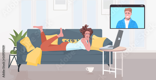 woman lying on sofa chatting with boyfriend in web browser window during video call online meeting self isolation concept horizontal full length vector illustration