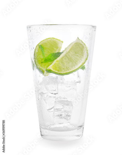 Glass with ice cubes, lime and mint on white background