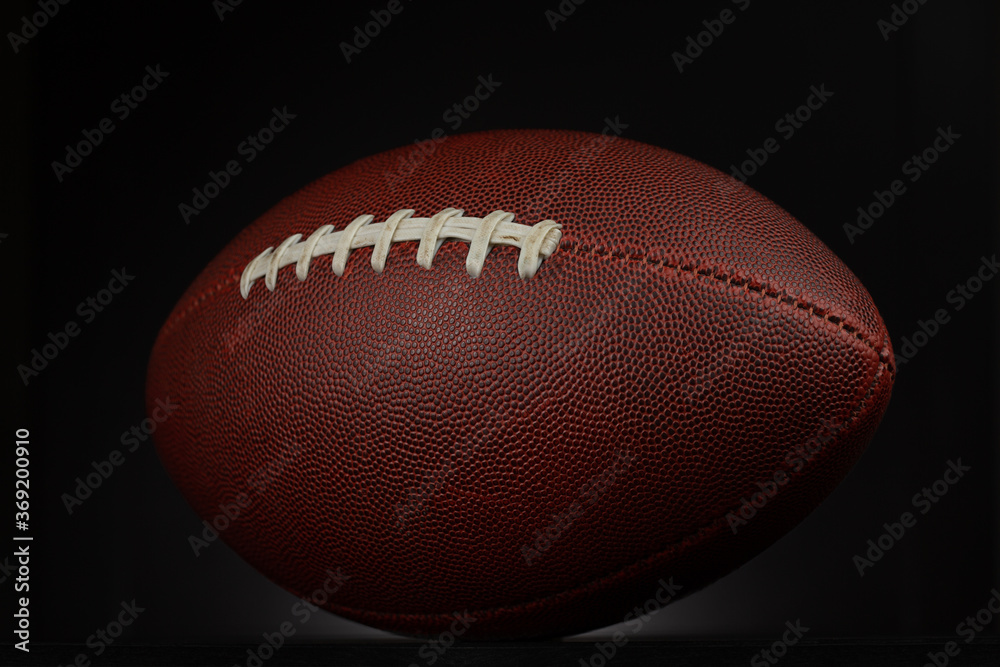 American football in a studio shot. The ball is over a black background that is lightly illuminated. American football in a studio shot. The ball is over a black background that is lightly illuminated.