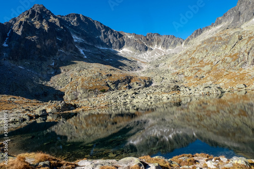  Pond in Valley of Five Spis Lakes surrounded by rocky summits, High Tatra Mountains, Slovakia.