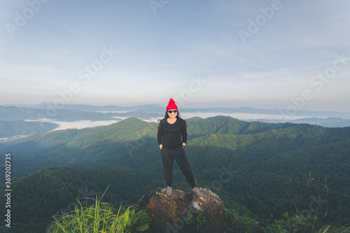 rear of happy woman stand on top mountain looking view with mist and cloud at morning light Soft focus. © suparat1983
