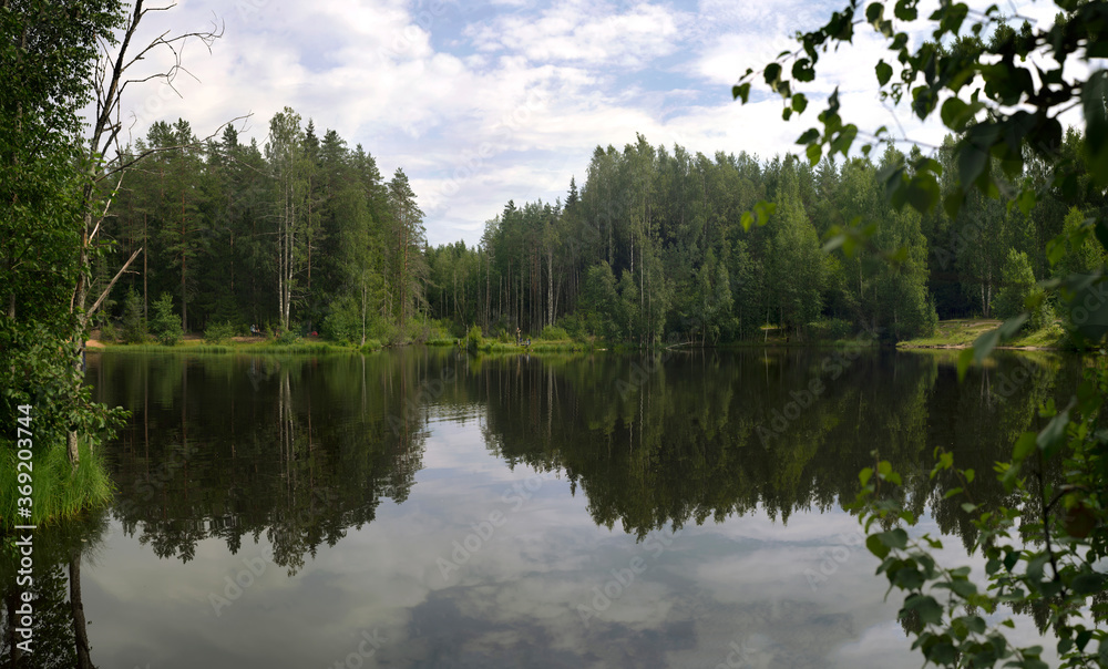 A small forest lake for fishing and tourism with tents . A small forest lake for fishing and tourism with tents .