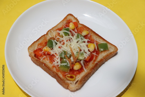Brown bread pizza, topped with sweet corn, vegetables and cheese, kids breakfast, Indian street food 