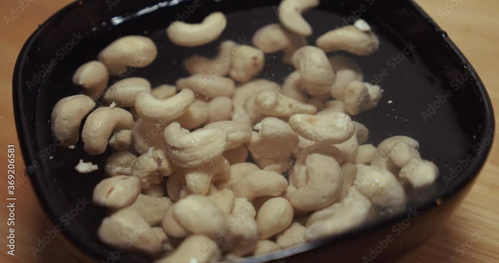 Peanuts soaking in water
in black bowl. Close up Peanuts soaking in water
in black bowl. Close up