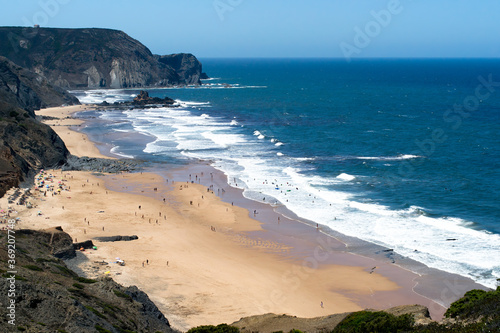 Aerial view of people, beach, sea and cliff. Sunny day at Cordoama beach, Algarve, Portugal. photo