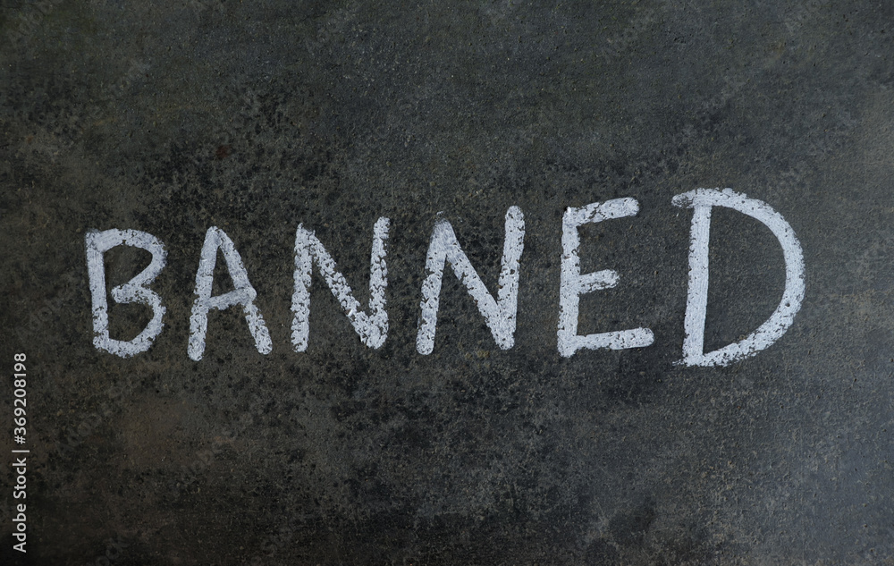 Banned Word Written on Blackboard with White Chalk Banned Word Written on Blackboard with White Chalk