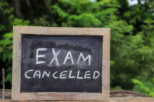 Exam Cancelled Phrase Written On Chalkboard with White Chalk photo