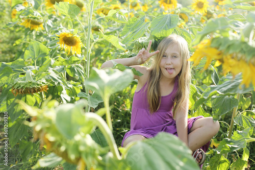 Portrait of cute girl enjoying of freedom in the sunflowers field