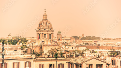 Rome skyline with old colorful houses and rooftop terraces on sunny day. Dome of San Carlo al Corso basilica on the background. Rome, Italy © pyty