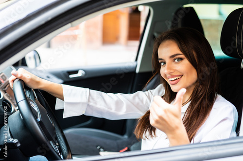 Portrait of a beautiful young woman with thumbs up in her new car © F8  \ Suport Ukraine