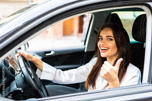 Portrait of a beautiful young woman with thumbs up in her new car © F8  \ Suport Ukraine