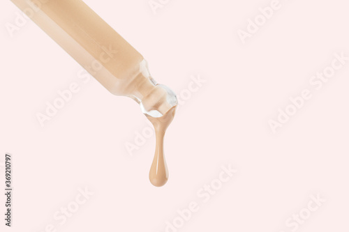 Obraz na płótnie Glass pipette with flowing matte nude foundation drop white background. Sample of cosmetic beauty makeup product. Liquid tint, fluid, beige concealer for contouring, skin tone correction. Copy space w salonie