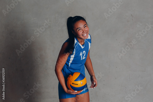 Young woman smiling volleyball player with ball.