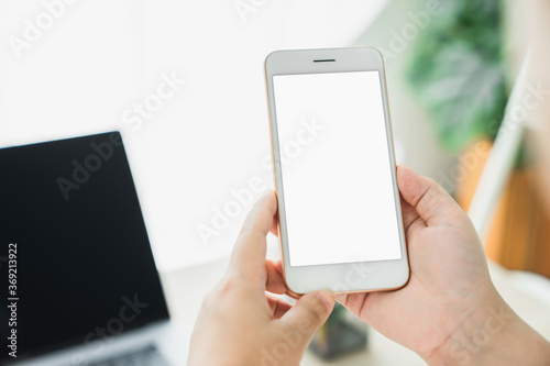 Woman hand holding smartphone and touching blank screen. Mockup of advertisement. © sataporn