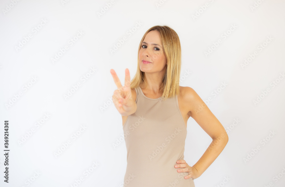 Beautiful blonde woman in beige dress gesturing Beautiful blonde woman in beige dress gesturing