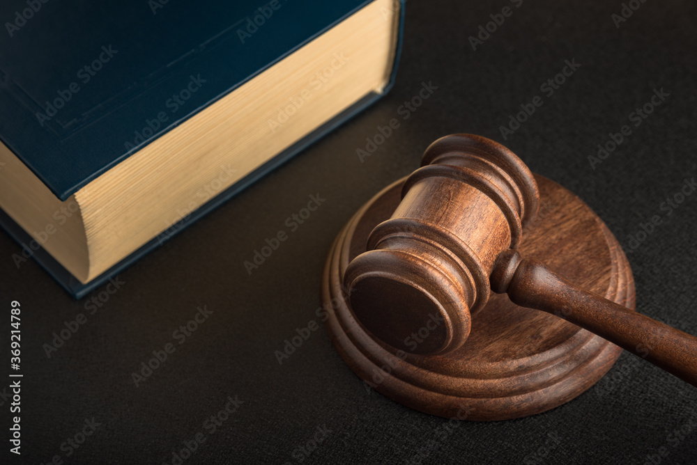 Judge gavel and book. Black background. Wooden hammer. Justice and law