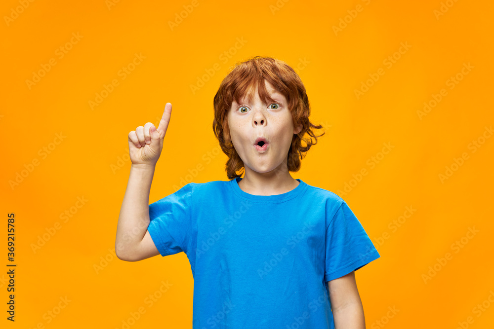 The red-haired child shows a thumb up and a blue T-shirt The red-haired child shows a thumb up and a blue T-shirt